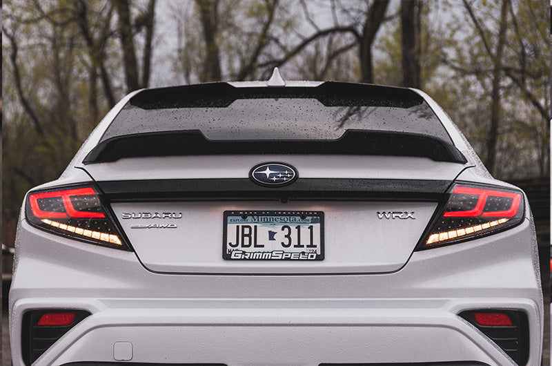 OLM Spec-AR LED taillights with clear lens, black base, and red bar for 2022+ Subaru WRX, showing the tail light design.